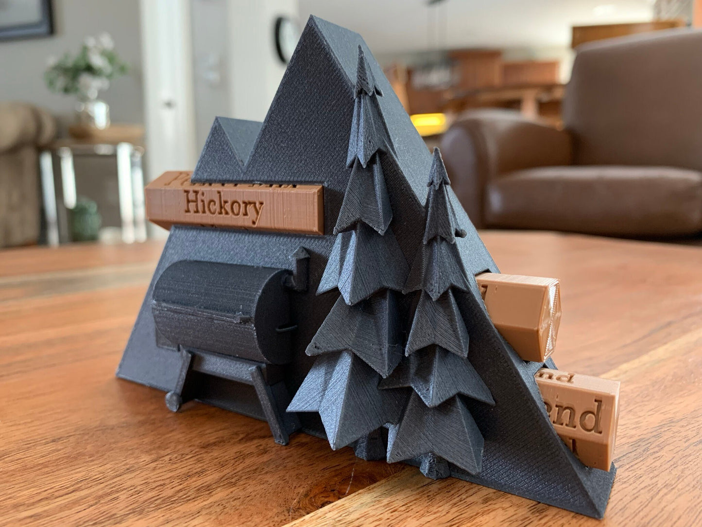 Close-up of a 3D printed pellet label magnet with detailed mountain design and hidden magnets inside the log for secure attachment.