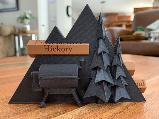 Close-up of a 3D printed pellet label magnet with detailed mountain design and hidden magnets inside the log for secure attachment.