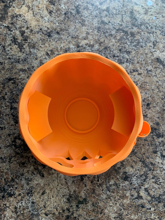 Top profile of the Pumpkin Party Cup Holder illuminated by its LED tea light, showcasing its jack lantern design.