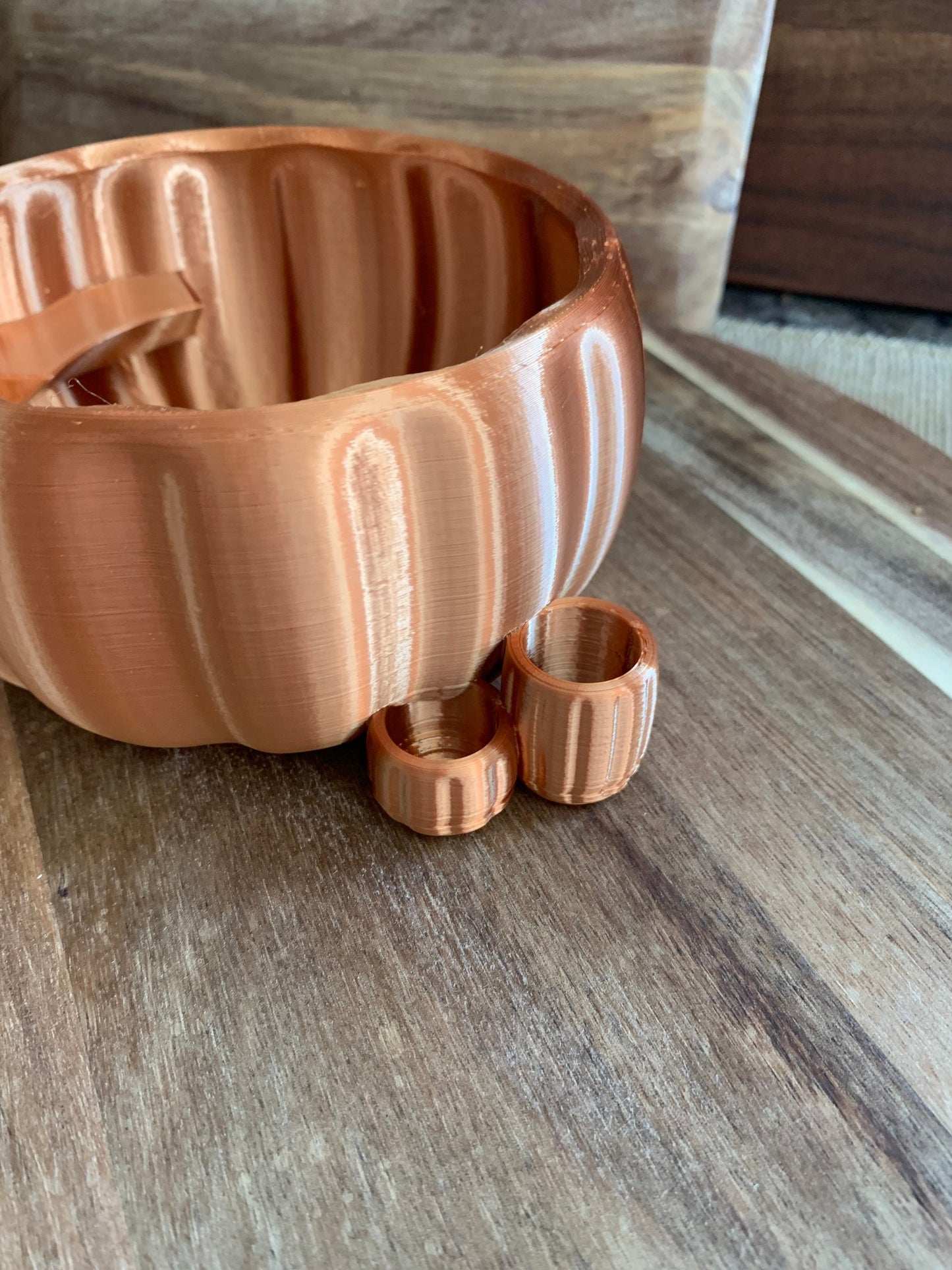 Side angle view of a copper pumpkin party cup holder displaying its rustic charm and marker slot detail.
