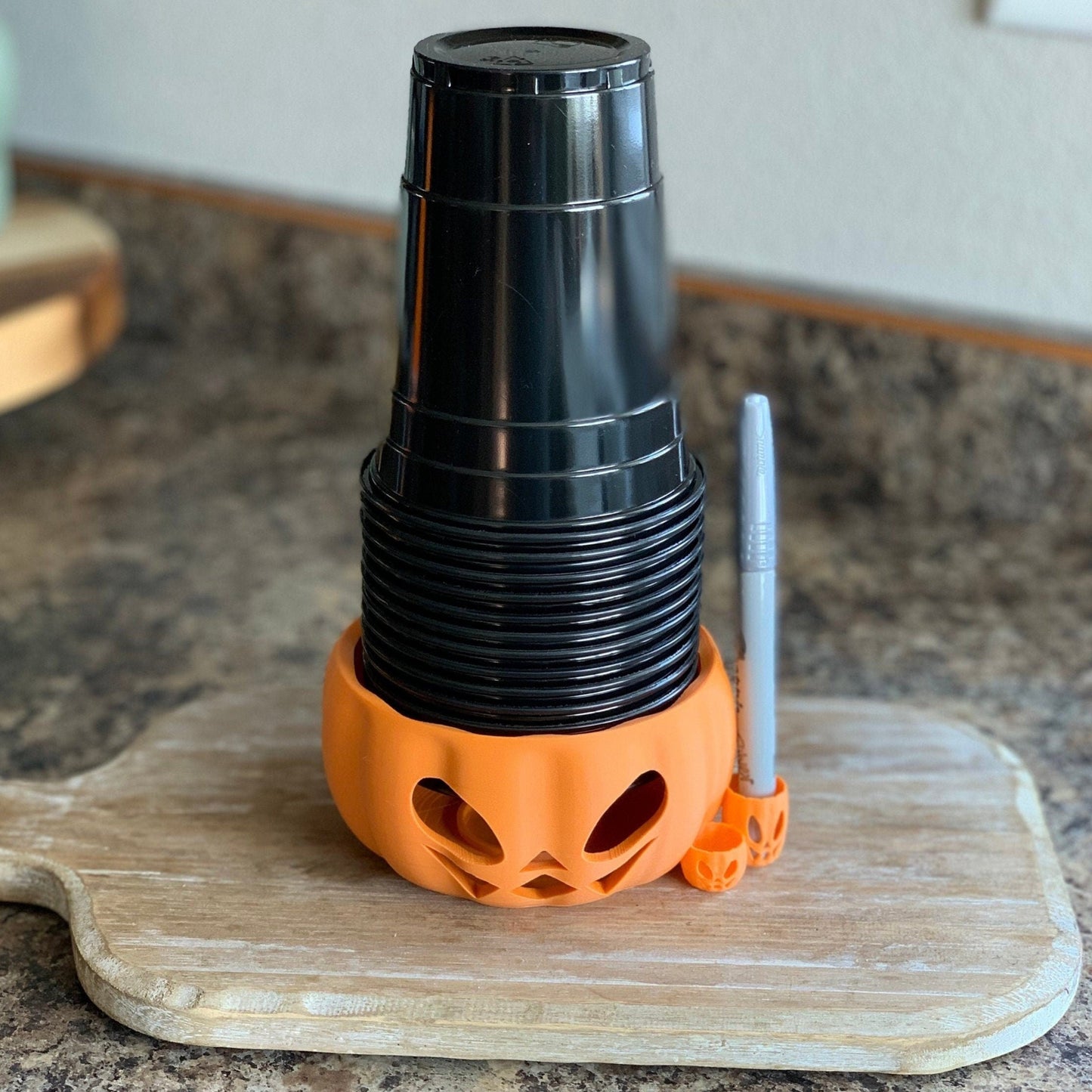 Product image of a Halloween drink cup holder featuring an integrated pen holder to prevent mix-ups.