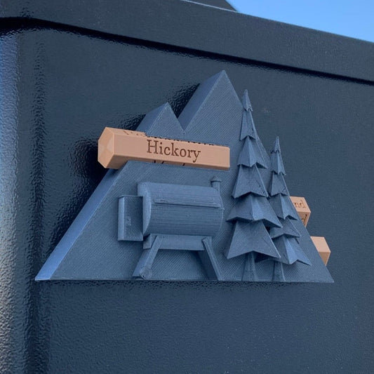 Pellet Label with trees, a grill in the shape of mountains. Interchangeable logs with wood types are displayed.